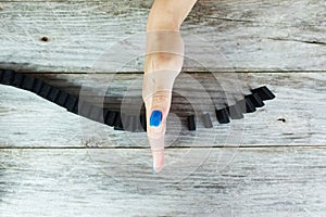 WomanÃ¢â¬â¢s hand stopping domino effect on wooden table, aerial or top view